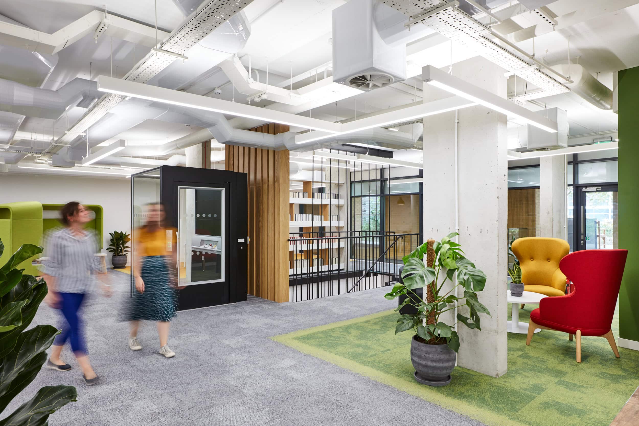 Two employees are shown walking through the BES office which achieved Gold SKA rating.