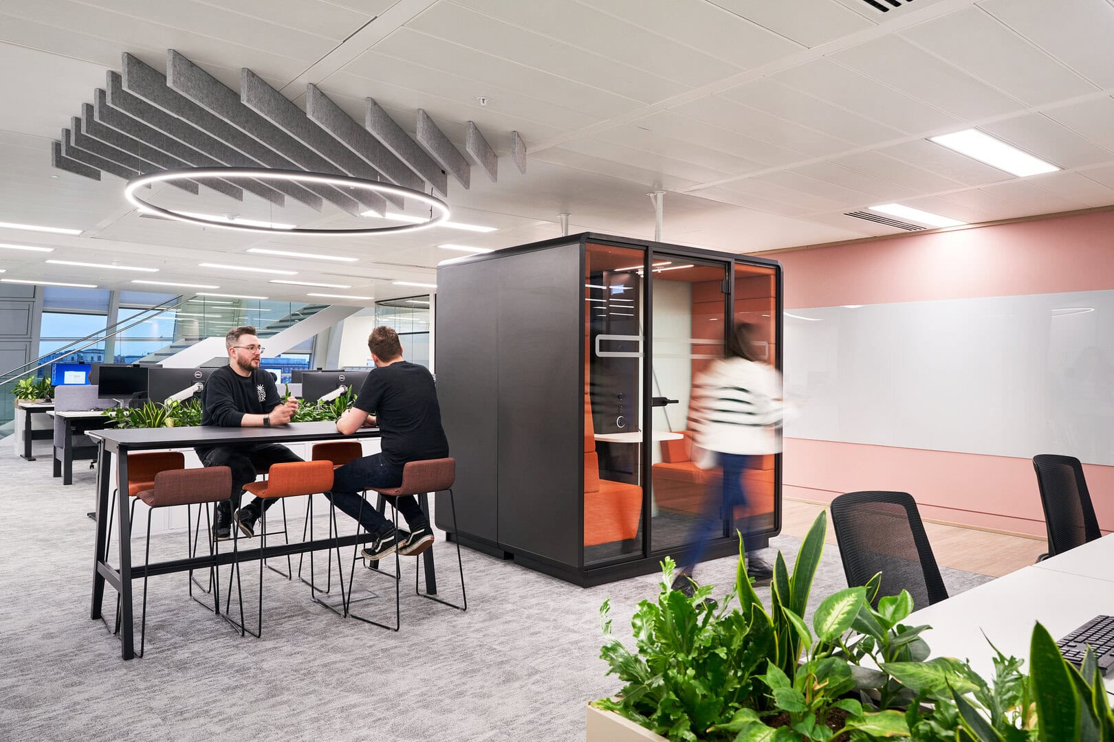 Employees are shown in an office that offers many different work settings which promotes neurodiversity.