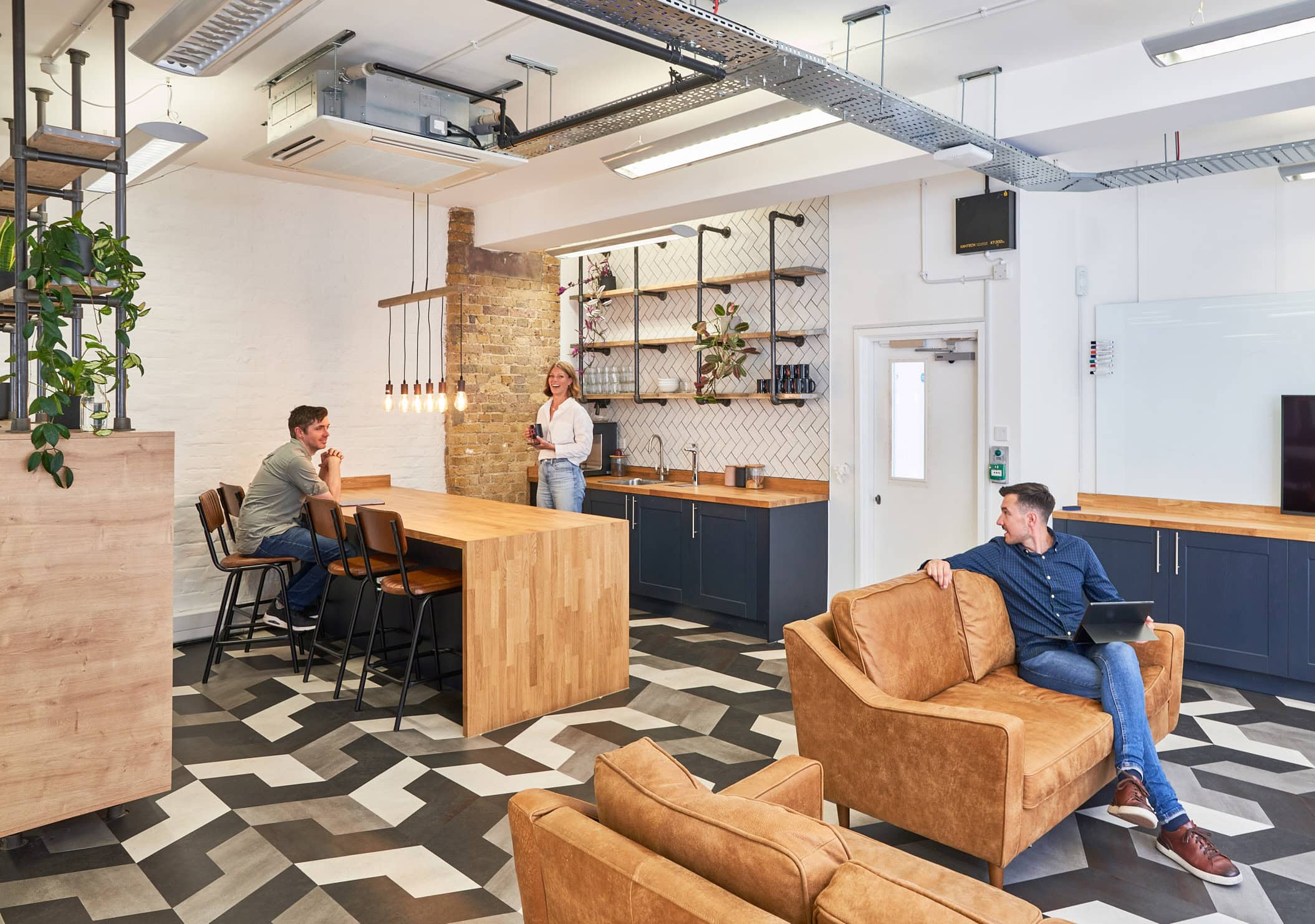 Millennial professionals participate in vibrant discussions within the contemporary kitchen breakout space, showcasing the latest Millennial workplace design trends.