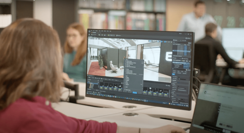 AIS employee is shown at a computer working on a 3D office model. 