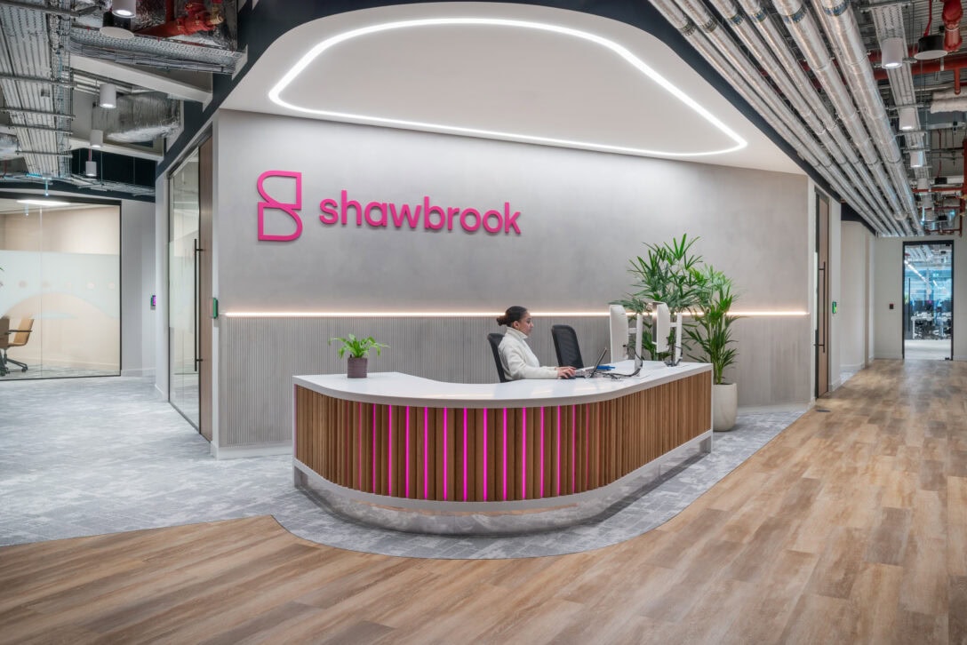 Grey background with curved reception desk with pink LED lights intertwined