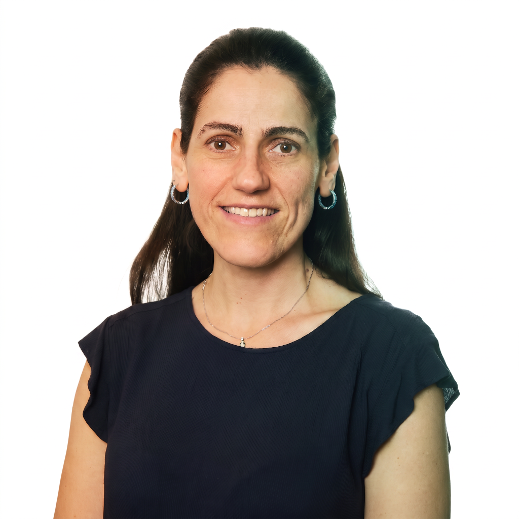A woman with long dark hair and hoop earrings smiles while wearing a navy blue top against a white background.