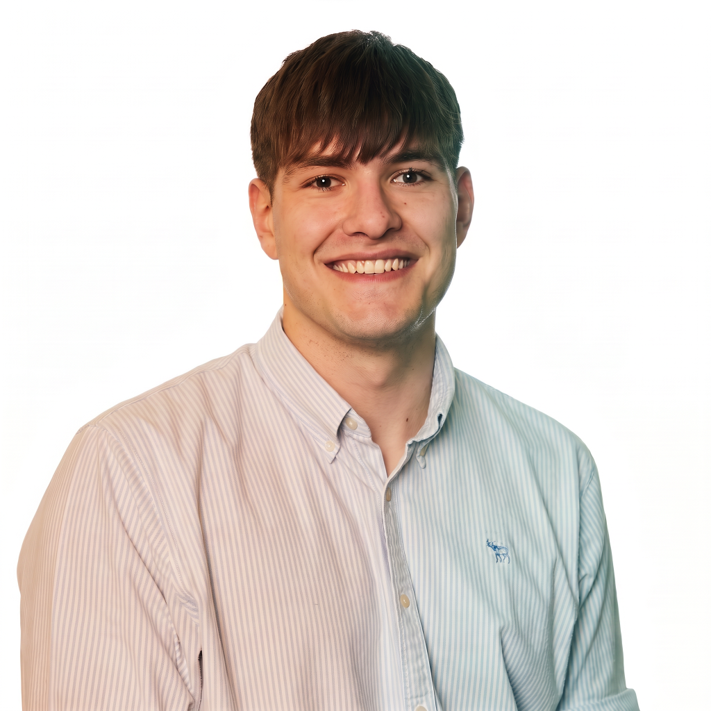 Smiling young man with short brown hair wearing a light blue and white striped shirt, against a white background.