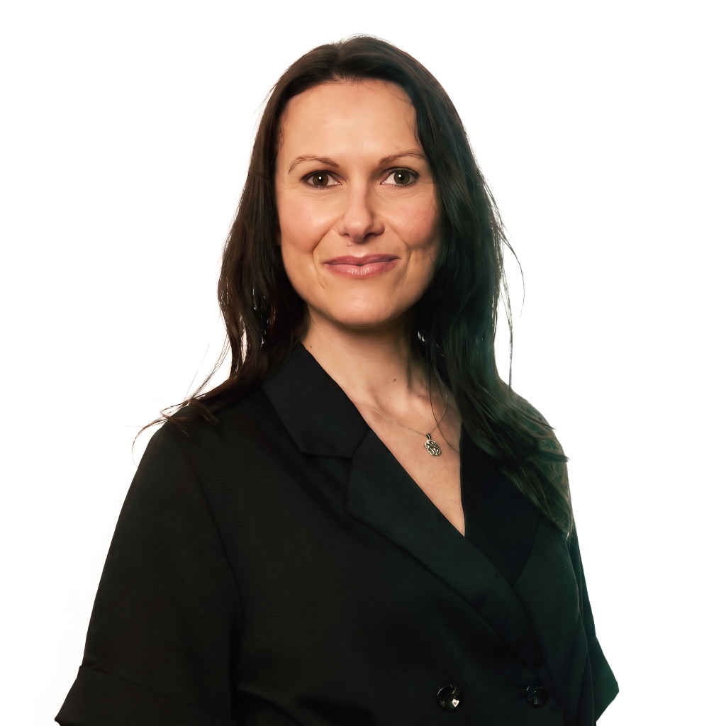 A woman with long dark hair smiles while wearing a black blazer against a white background.