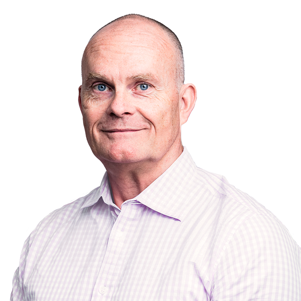Man with a shaved head and blue eyes, wearing a light purple checkered shirt, smiling against a transparent background.