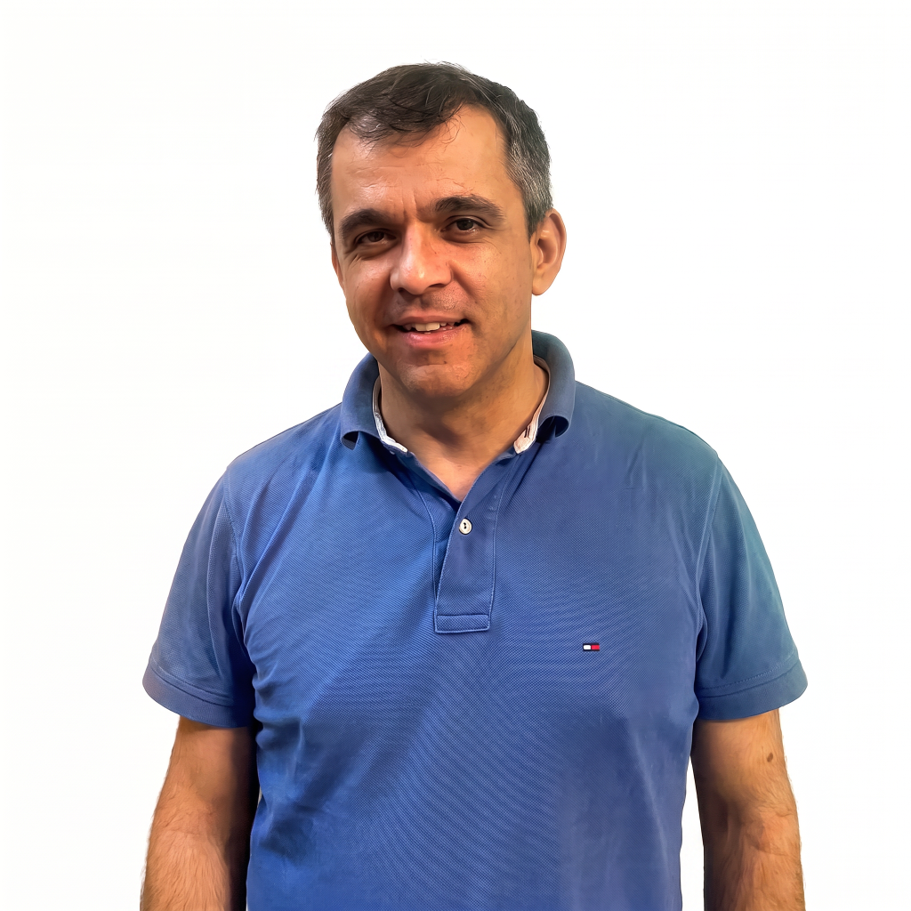 Man with short hair wearing a blue polo shirt, smiling against a white background.
